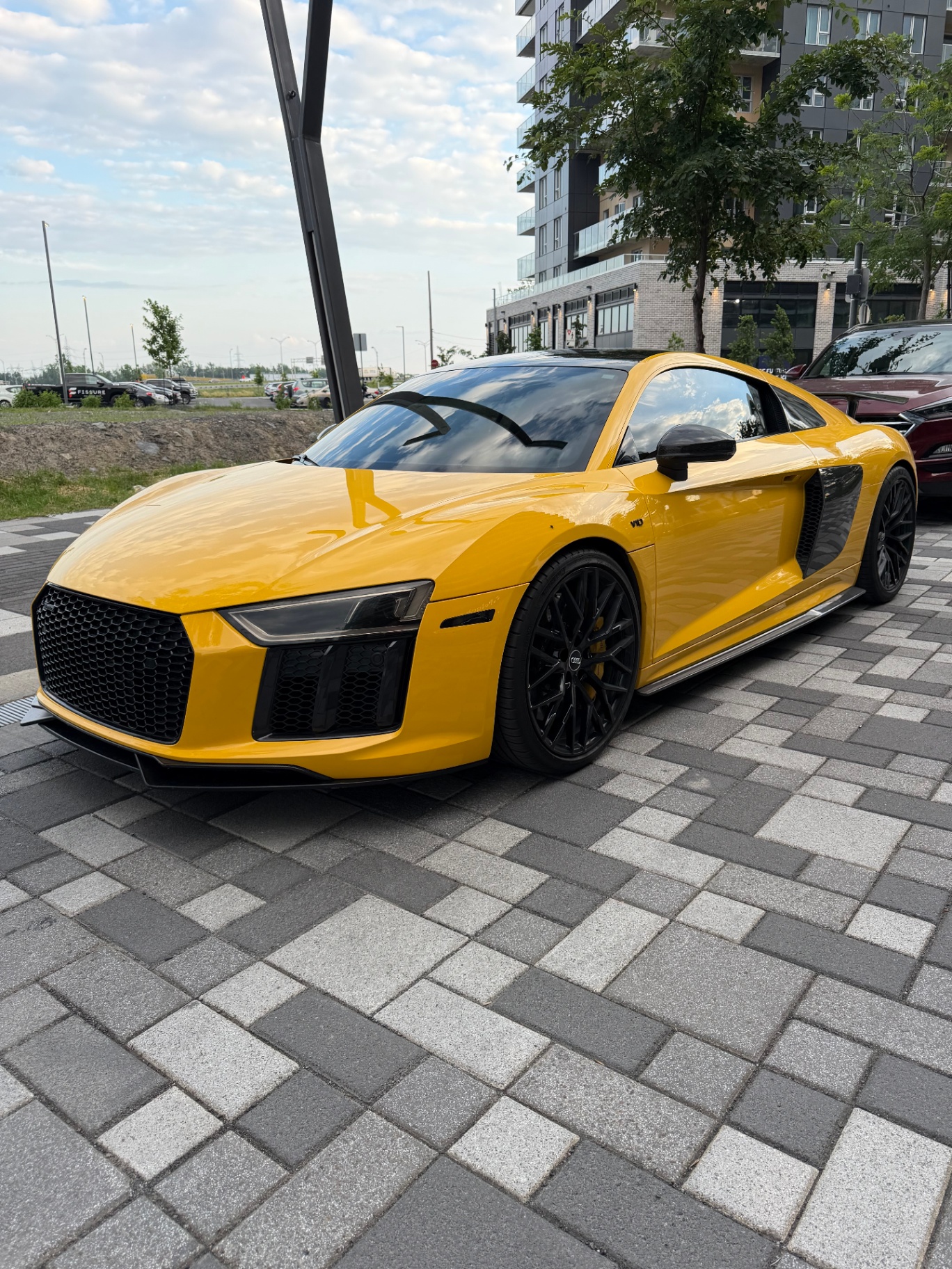 Audi R8 jaune, vue de face sur une plaza urbaine